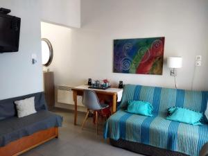 a room with a bed and a desk and a couch at KASTRO HOUSE in Skopelos Town