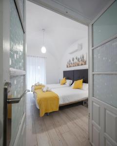a bedroom with a bed with a yellow blanket on it at Apartamentos Gladiador in Merida