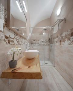 een badkamer met een wastafel en een glazen douche bij Apartamentos Gladiador in Merida