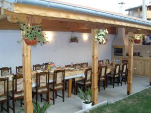 a dining area with a long table and chairs at Karadzhovy Guest House in Kalofer