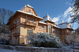 a large building with a balcony in the snow at Jestřabí in Luhačovice