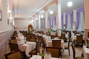 a dining room filled with tables and chairs with white tablecloths at Gran Hotel Balneario in Baños de Montemayor