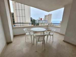 a white table and chairs on a balcony with a view at Torres Gardens-Fincas Benidorm in Benidorm