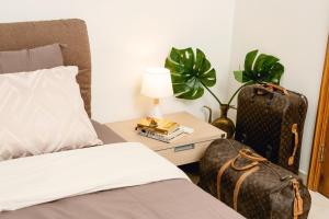 a bedroom with a bed and a table with a suitcase at Private rooms in seafront apartment in Sliema