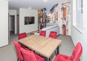 una sala da pranzo con tavolo e sedie rosse di Apartamenty Piano a Świeradów-Zdrój