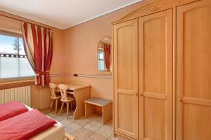 een slaapkamer met een bed, een tafel en een bureau bij Chalet Betty Appartamento Pec in Livigno