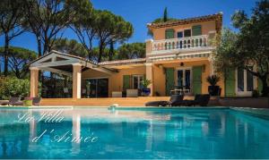 a villa with a swimming pool in front of a house at La Villa D’Aimée in Vidauban