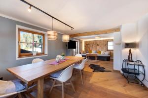 a dining room and living room with a wooden table and chairs at Ferienwohnung Riesserbaur in Garmisch-Partenkirchen