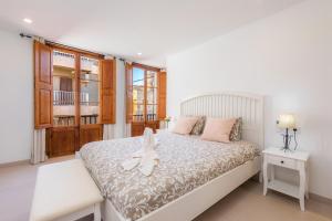 a bedroom with a white bed and a window at Ca Na Lola in Porto Cristo