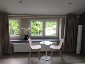 a table and two chairs in front of a window at Le Jardin du Thé Bord de la Meuse in Namur
