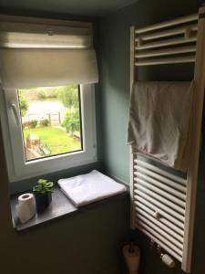 baño con ventana y asiento junto a la ventana con planta en Le Jardin du Thé Bord de la Meuse, en Namur