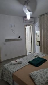 1 dormitorio con cama y pared blanca en Nacif's Suites, en Río de Janeiro