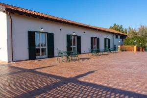 a building with tables and chairs on a brick patio at Camia Etna House in Piedimonte Etneo