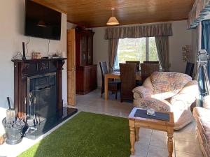 ein Wohnzimmer mit einem Sofa und einem Kamin in der Unterkunft Cottage 396 - Roundstone in Roundstone