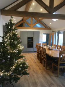 Un árbol de Navidad en un comedor con mesa en Fullers Hill Cottages, en Little Grandsen