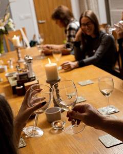 um grupo de pessoas sentadas numa mesa com copos de vinho em Fullers Hill Cottages em Little Grandsen