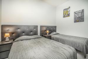 a bedroom with two beds and two lamps on tables at Apartamentos Lux Dinastia in Lisbon