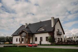 a red car parked in front of a house at Rusiborek Dom in Połażejewo