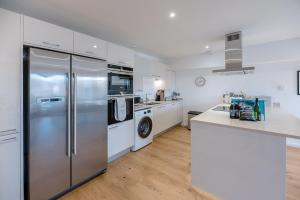 a kitchen with stainless steel appliances and white cabinets at 2 Deben Wharf Woodbridge Air Manage Suffolk in Woodbridge