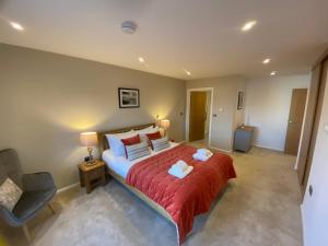 ein Schlafzimmer mit einem großen Bett mit einer roten Tagesdecke in der Unterkunft 2 Deben Wharf Woodbridge Air Manage Suffolk in Woodbridge