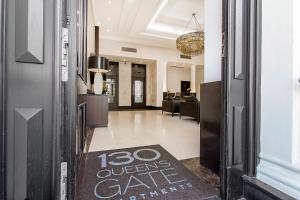 a door with a sign that reads queens care returns at 130 Queen's Gate Apartments in London