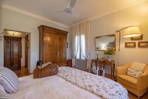 a bedroom with a large bed and a chair at Casa Bellavista B&B in Cortona