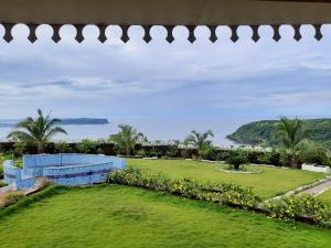 uma vista para o jardim a partir da casa em Windsongs A Premium Seaview Tropical Village em Ratnagiri