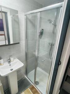 La salle de bains est pourvue d'une douche et d'un lavabo. dans l'établissement Femros Cosy one bed apt,12mins to Birmingham city ctr, à Birmingham