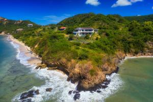 an aerial view of a house on a hill next to the ocean at Villa Utamaro in Bumbang