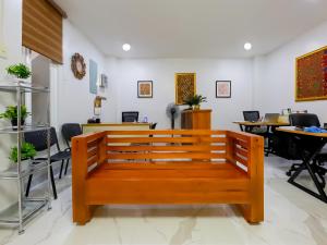 - un banc en bois dans une pièce avec des tables et des chaises dans l'établissement OYO 848 Dona Aurora Condotel, à Manille