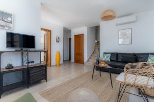 ein Wohnzimmer mit einem Sofa und einem TV in der Unterkunft 7 Piedras in Playa Blanca