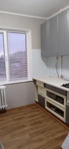 an empty kitchen with a counter and some windows at Василя Стуса 10/77 City Rooms in Bila Tserkva +7 photos
