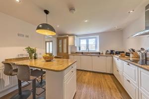 a kitchen with a large island with a counter top at 3 Bedroom Barn Conversion -Garden View - Ty Cerrig Barn in Corwen