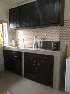 a kitchen with a sink and a microwave on a counter at Your home II in Yaoundé