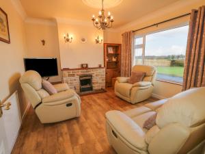 a living room with two chairs and a fireplace at Derryallen View in Enniskillen