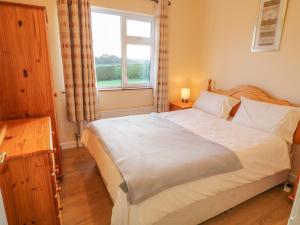 - une chambre avec un grand lit et une fenêtre dans l'établissement Derryallen View, à Enniskillen