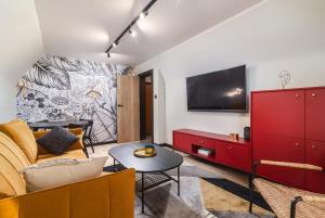 salon z kanapą i telewizorem na ścianie w obiekcie Valve Old Town w Gdańsku