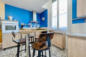 a kitchen with blue walls and a counter with stools at The City in the Country #CB in Gières