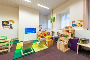 une salle de classe avec des bureaux, des chaises et des jouets dans l'établissement Hotel Terrace, à Engelberg