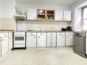 cocina grande con armarios y electrodomésticos blancos en SAD181 - Zentrale Monteurwohnung, en Schwandorf