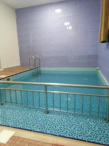 - une piscine avec une balustrade en métal dans un bâtiment dans l'établissement شاليهات الشاطيء beach chalets, à Salalah