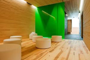 a room with white stools and a green wall at Alpenhotel Krone in Pfronten