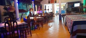 a restaurant with tables and chairs in a room at New Imperial Hotel in Hikkaduwa