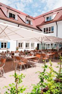 a patio with tables and umbrellas in front of a building at Alpenhotel Krone in Pfronten