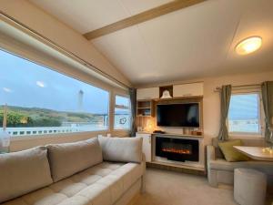 a living room with a couch and a tv at The Hudson @ Silversands in Lossiemouth