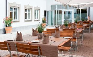 a row of tables and chairs with napkins on them at Alpenhotel Krone in Pfronten