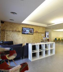 a living room with a couch and a tv on a wall at Dream Cube Hostel in Barcelona