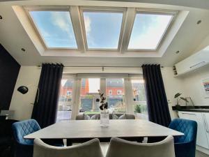 a dining room with a table and some windows at Stunning 4 Bed House with Cinema Room & Parking in Manchester