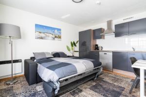 a bedroom with a bed and a kitchen at Lange Duinen in Hollum