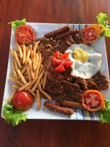 a plate of food with eggs and french fries at New Imperial Hotel in Hikkaduwa